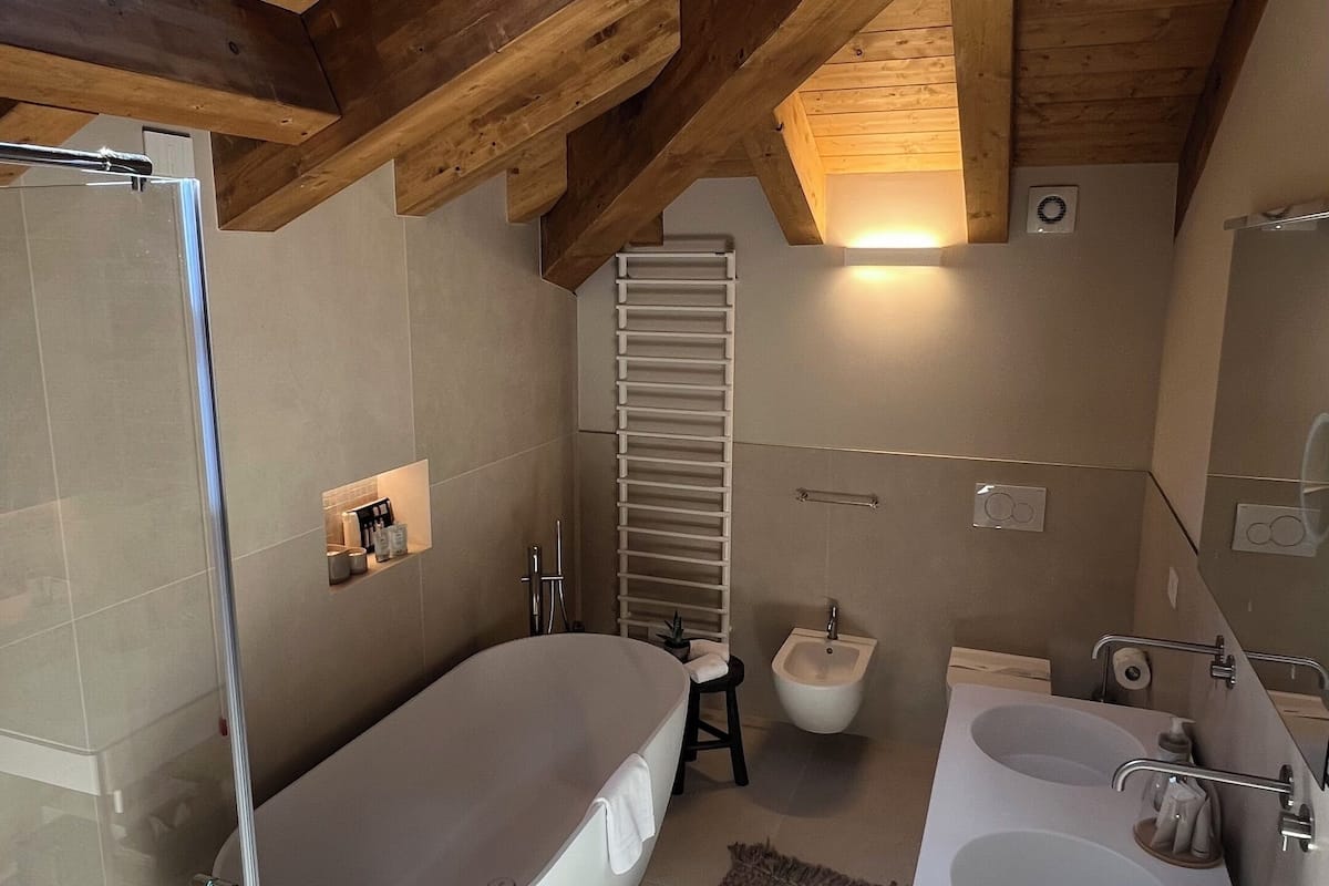 premium room, 1 king bed with sofa bed, lake view | bathroom | hair dryer, slippers, towels, soap