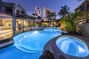 Un hotel con piscina, mobiliario exterior y vistas de los edificios circundantes.