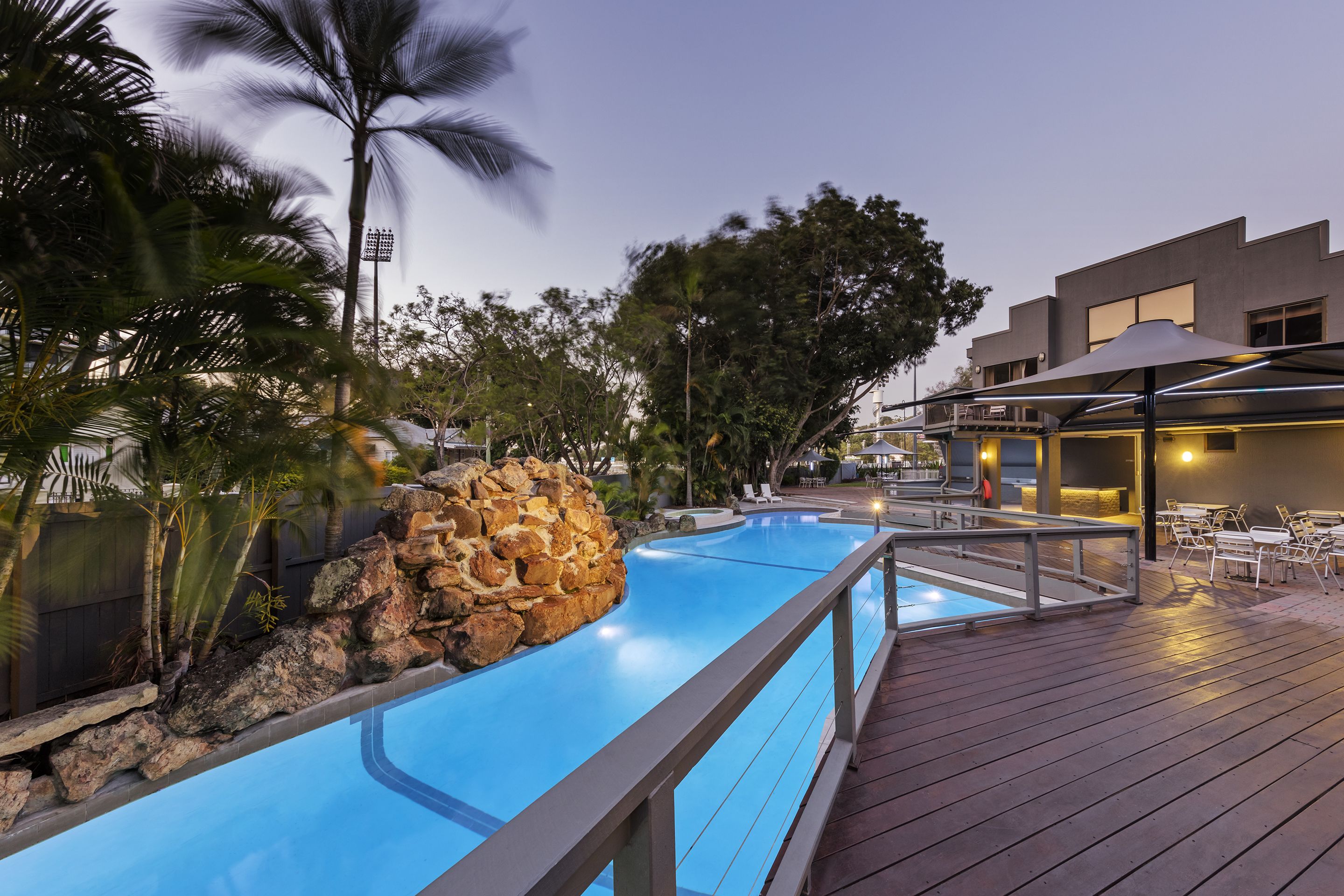 Una piscina al aire libre, sombrillas, sillones reclinables de piscina