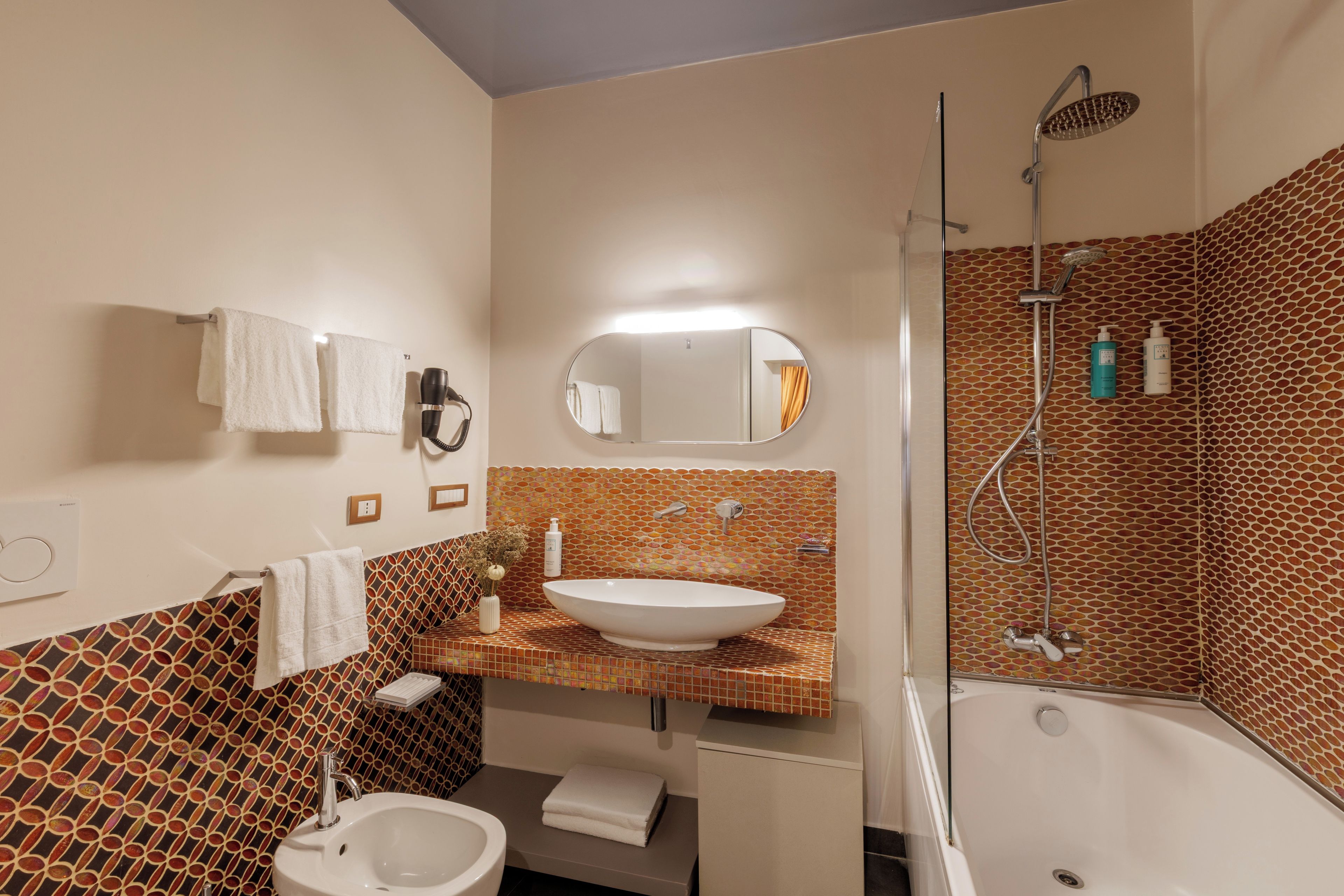 A bathroom with a bathtub, a sink, a toilet, a shower, and a mirror.