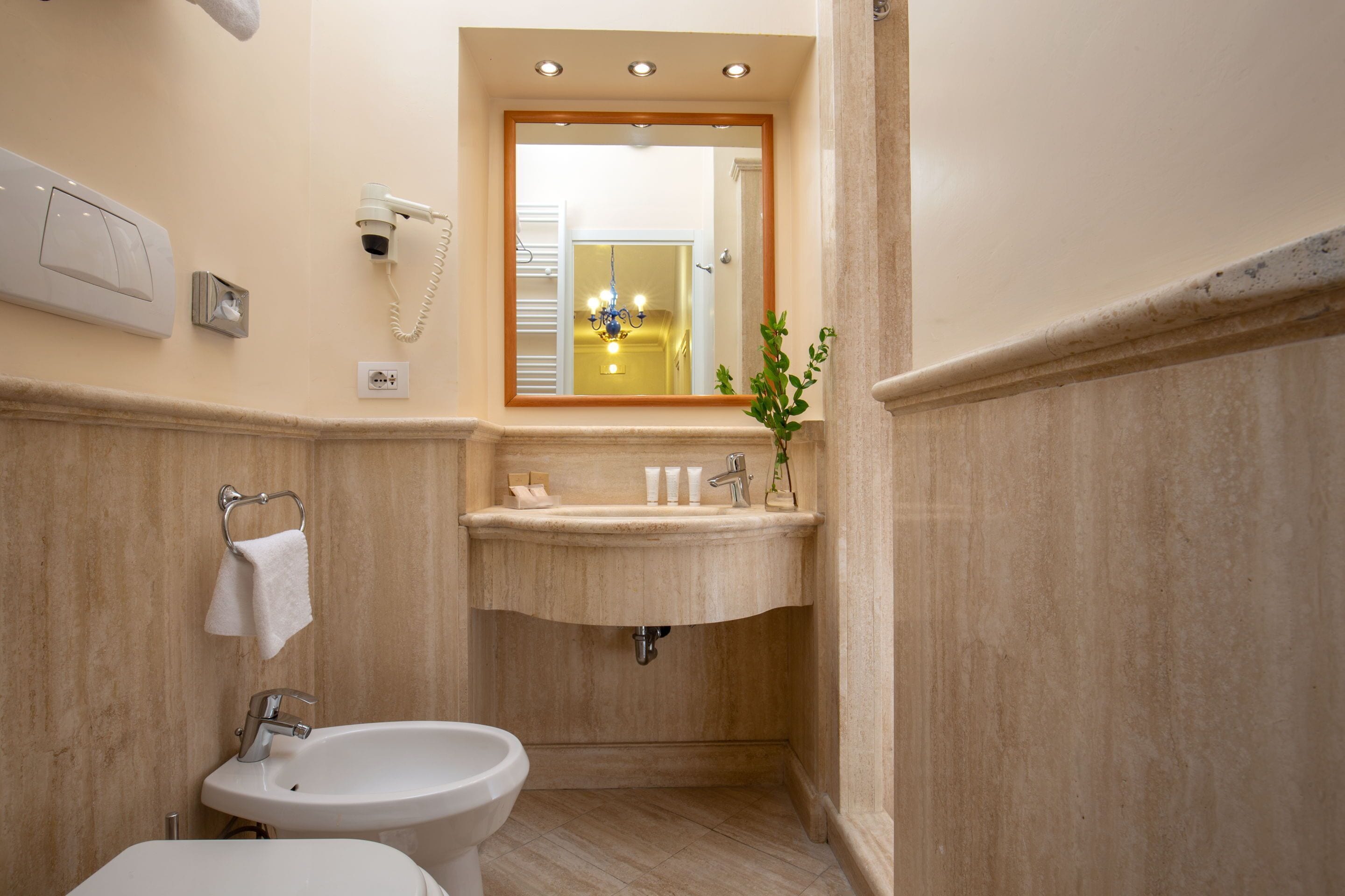 Un baño con lavabo, espejo e inodoro.
