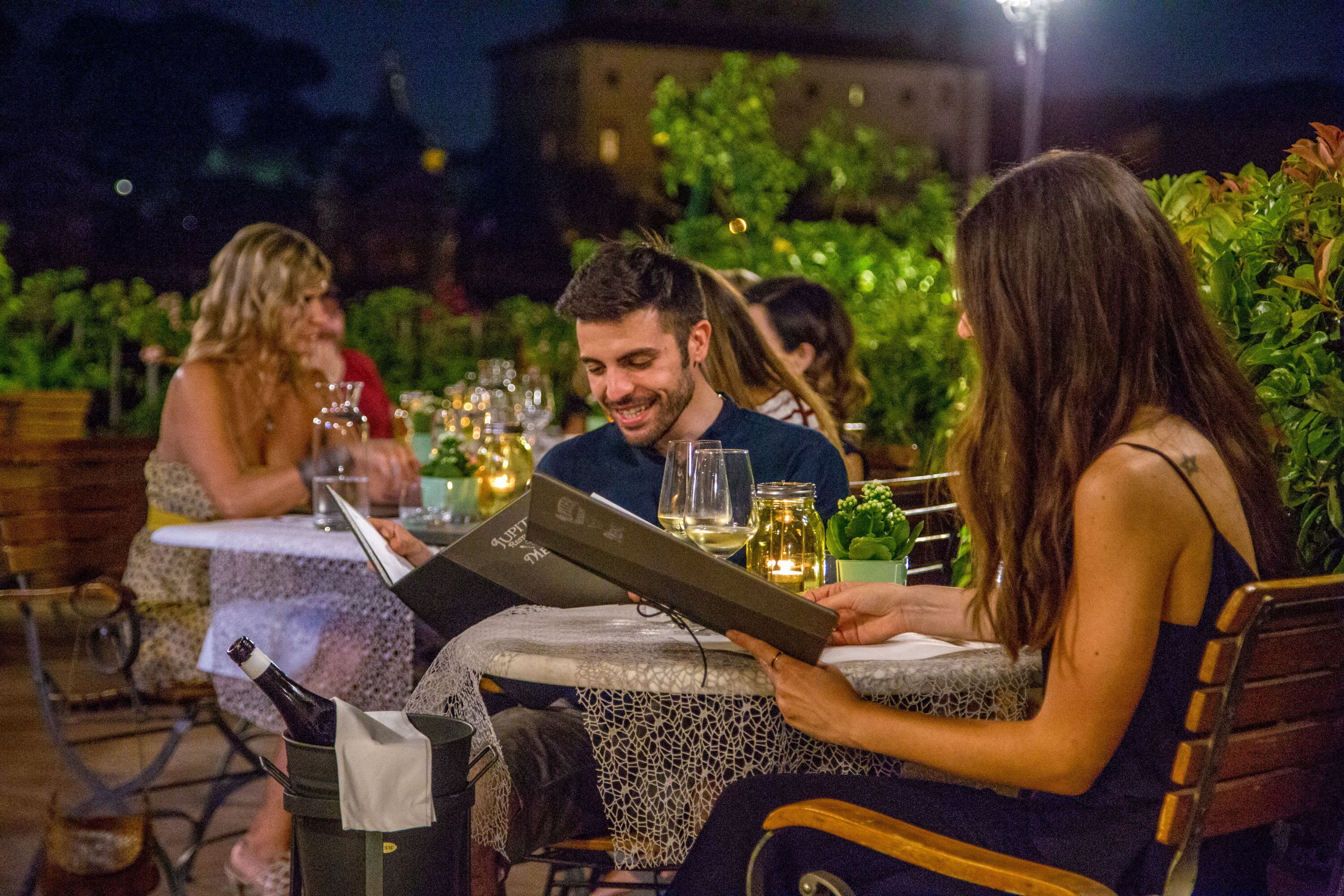 A group of people dining outdoors at night.