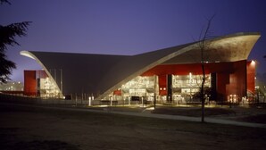 Un edificio moderno con un diseño arquitectónico único, que destaca por un amplio techo voladizo y varios niveles.