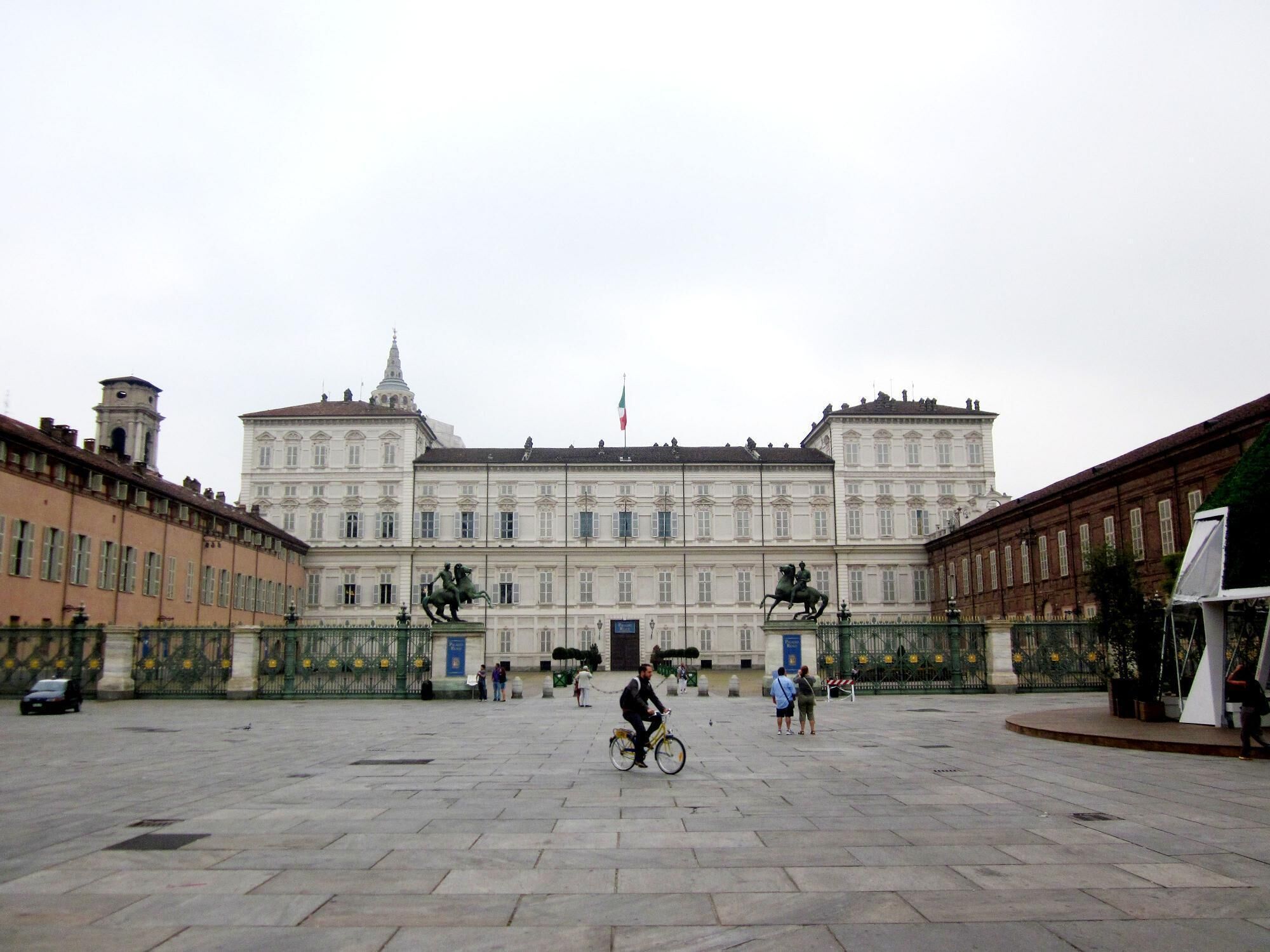Un gran edificio histórico con arquitectura clásica, un patio central y estatuas.
