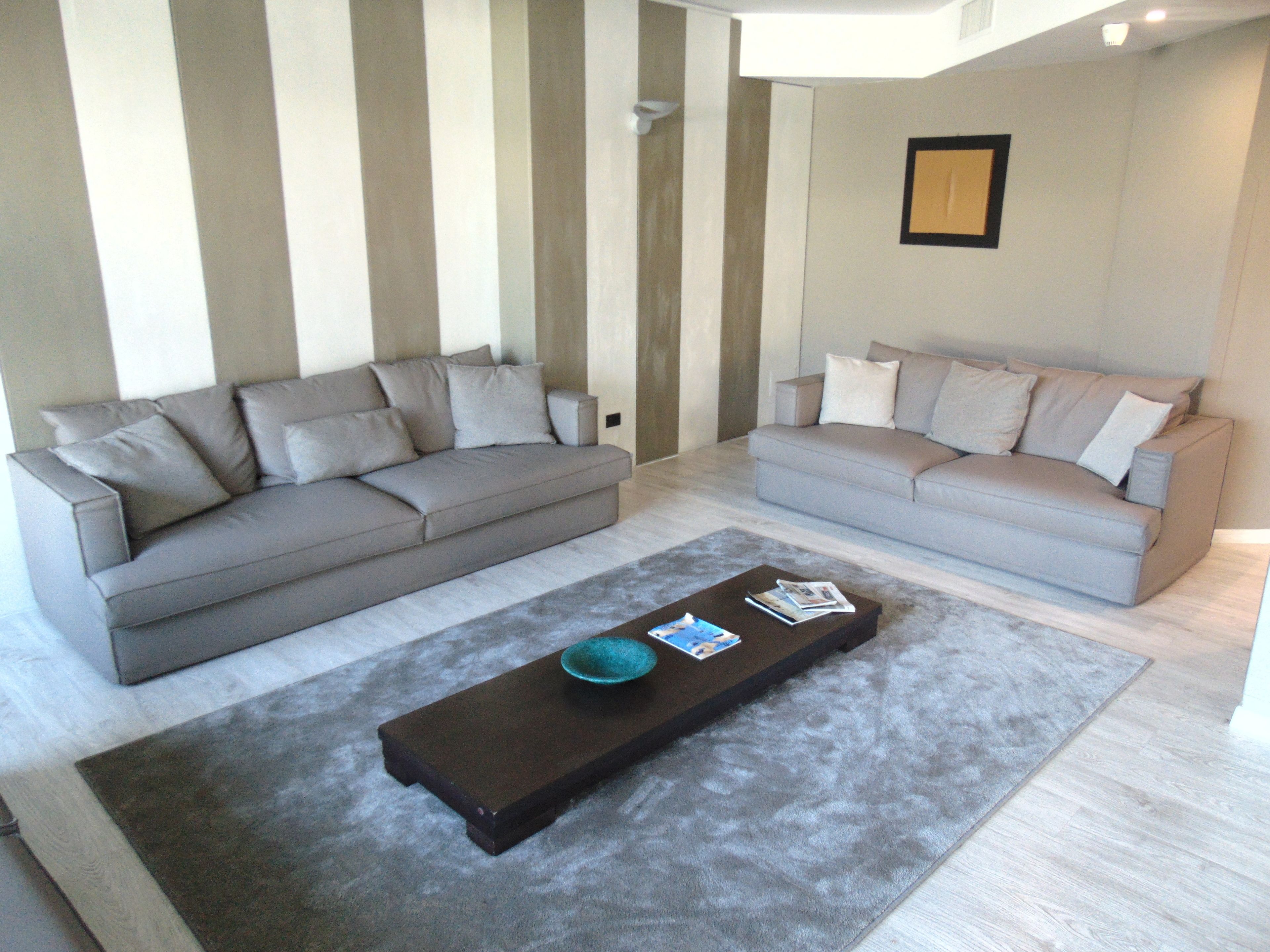 A living room with two sofas, a coffee table, and a rug.