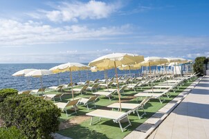 Praia particular, espreguiçadeiras, guarda-sóis 