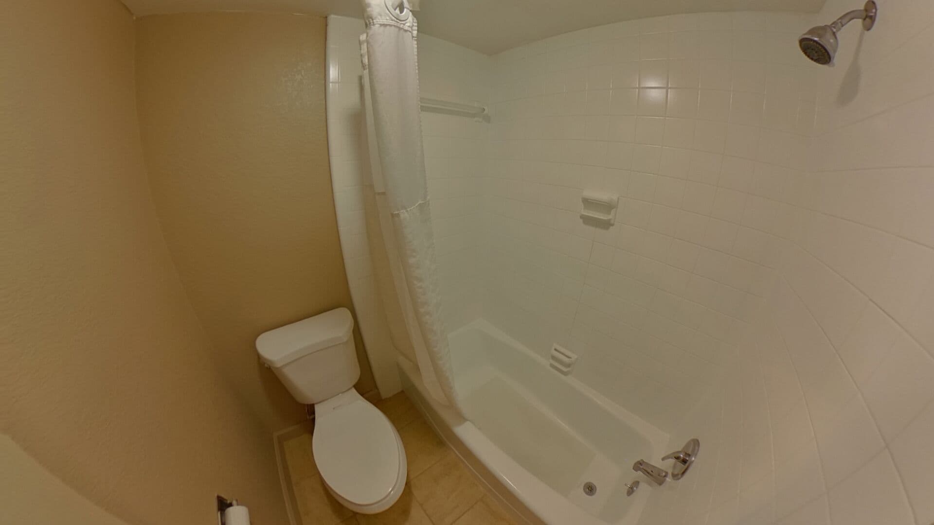 A bathroom with a toilet, a bathtub, and a shower.