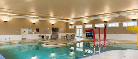 Una piscina interna profonda 12 metri, con spogliatoio e area relax con tavoli e sedie.