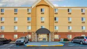 A multi-story hotel with a central lobby, parking lot, and accessible parking spaces.