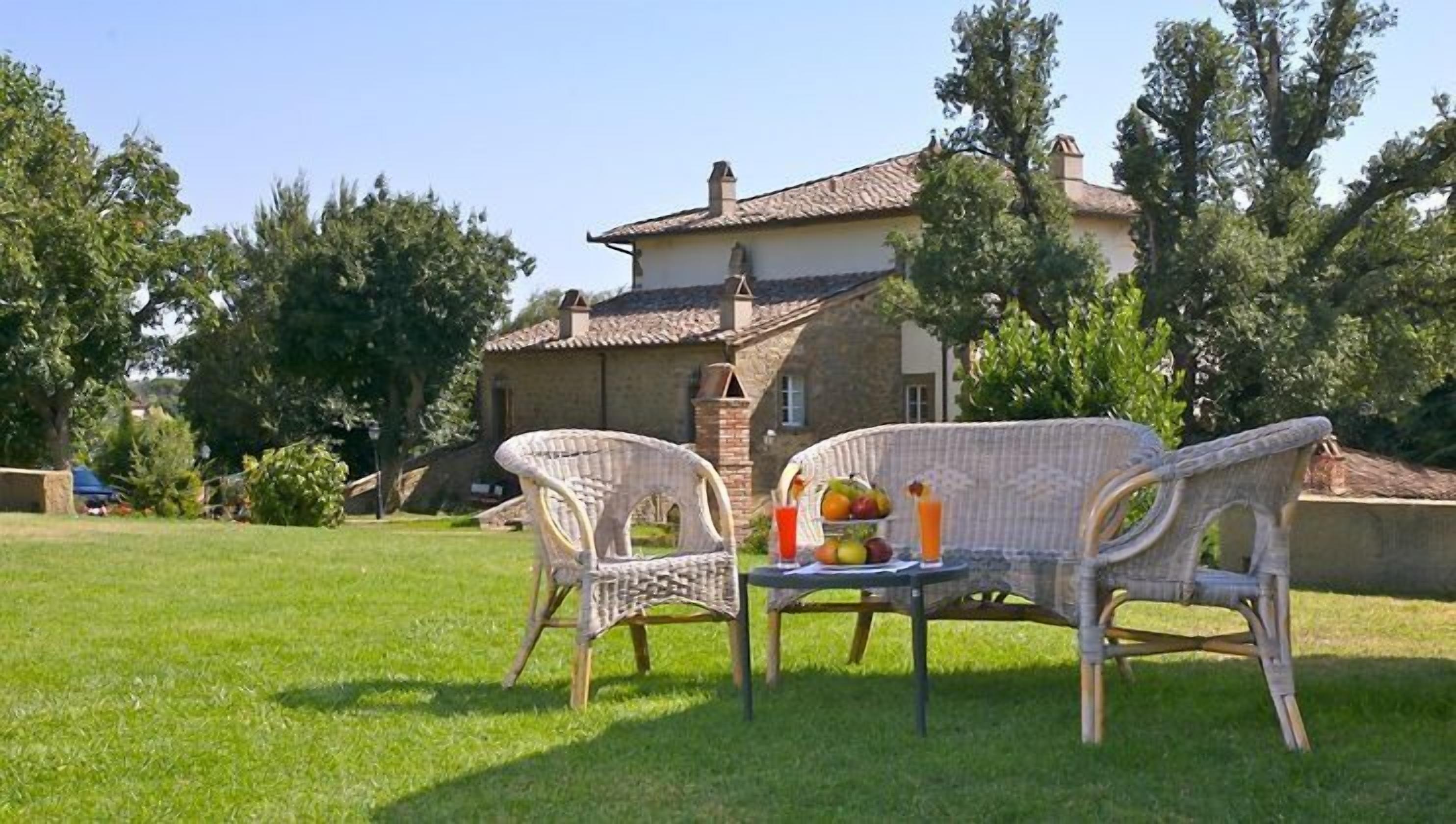 Un patio con mobiliario de mimbre y una cesta de frutas.