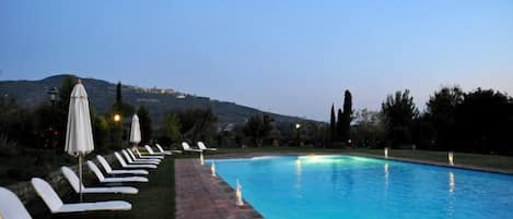 Una piscina al aire libre de temporada, sombrillas