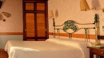 Una habitación de hotel con cama, escritorio, silla, lámpara y puerta.