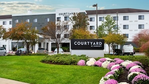 A Courtyard by Marriott hotel with a sign, parking, and landscaped flower beds. - Courtyard by Marriott Middletown Goshen (Middletown)