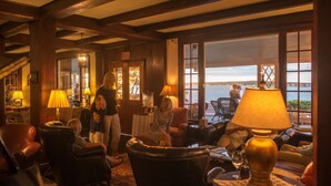 A cozy lobby with leather chairs, a fireplace, and a view of the sea. - Black Point Inn (Scarborough)