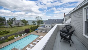 A residential property with a pool, outdoor seating, and a view of a lake.