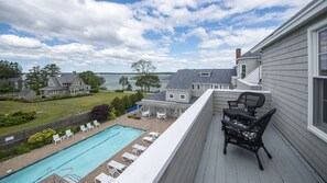 A residential property with a pool, outdoor seating, and a view of a lake.