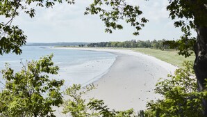 A beach with a clear view of the water and a grassy area in the background. - Black Point Inn (Scarborough)
