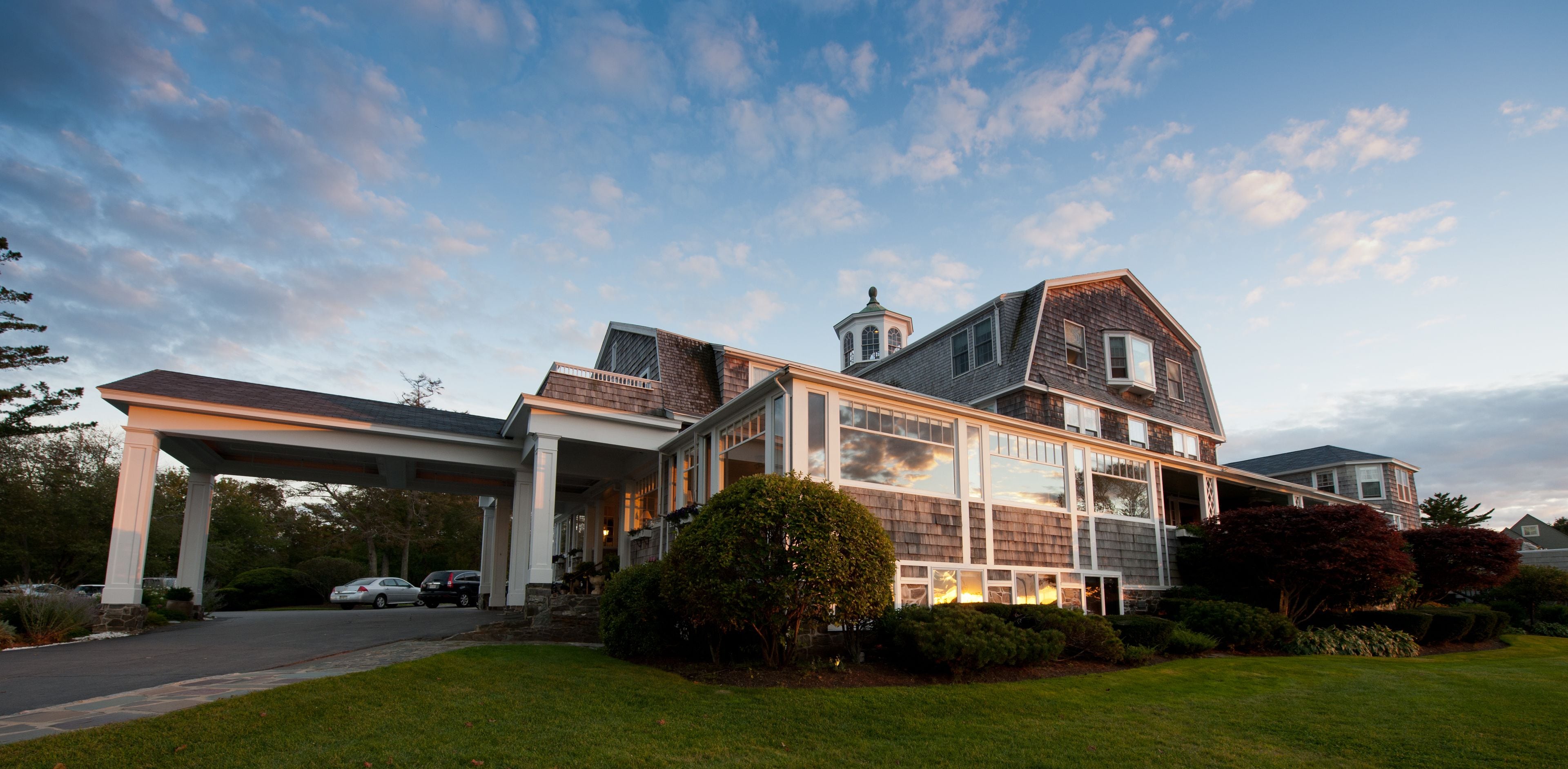 A large, modern house with a covered driveway and multiple windows.