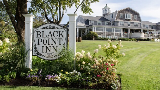 A sign for Black Point Inn with a well-maintained lawn and garden in front. - Black Point Inn (Scarborough)