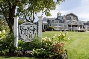 A sign for Black Point Inn with a well-maintained lawn and garden in front. - Black Point Inn (Scarborough)