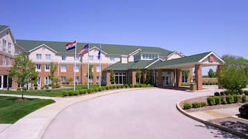 Hotel entrance with a covered waiting area and beautifully landscaped surroundings.