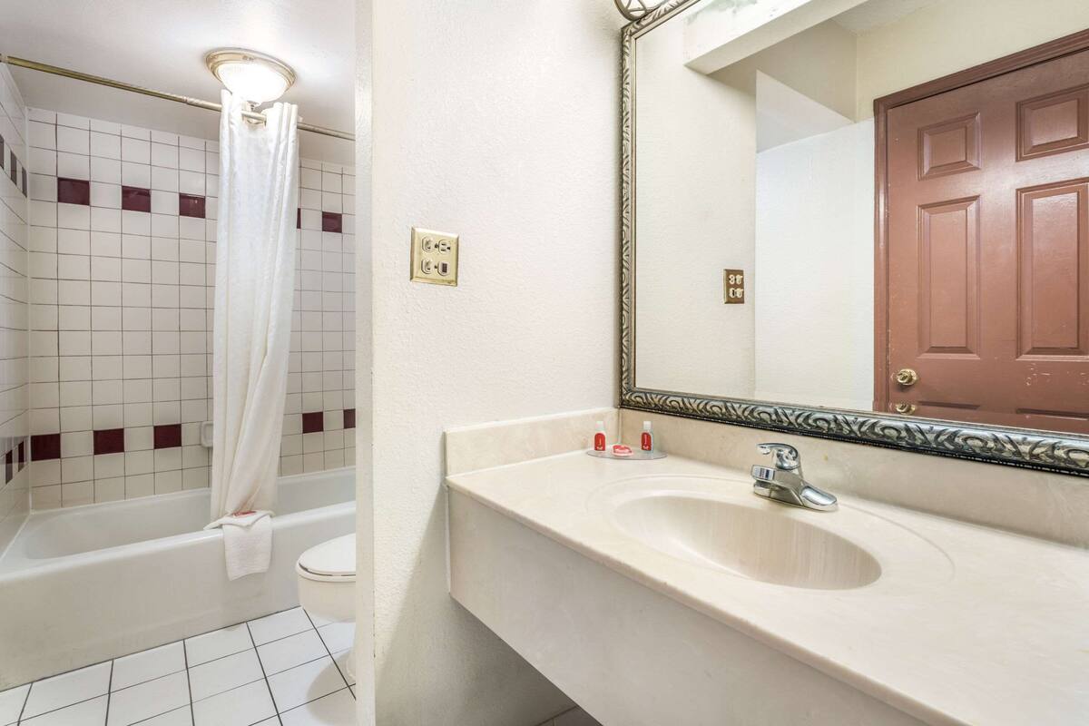 Une salle de bain équipée d’une baignoire, de toilettes, d’un lavabo et d’un miroir.