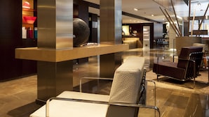 A modern lobby with a reception desk, seating area, and a large decorative vase. - AC Hotel Irla by Marriott (Barcelona)