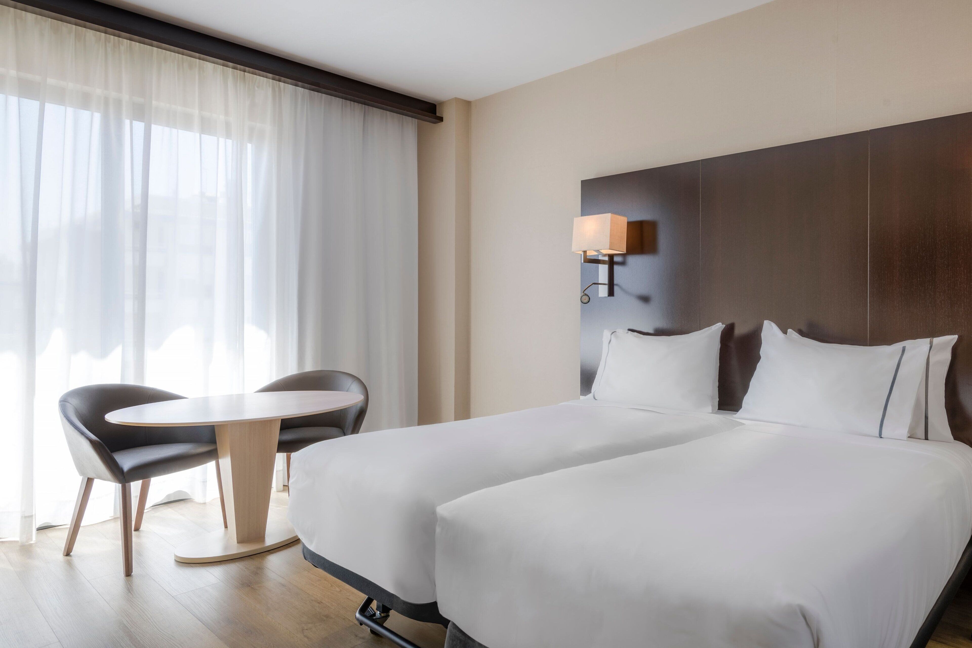 Una habitación de hotel con una cama, un escritorio y una silla.