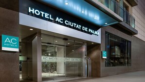 The exterior of Hotel AC Ciutat de Palma, featuring a modern facade with large glass windows and a prominent signage.