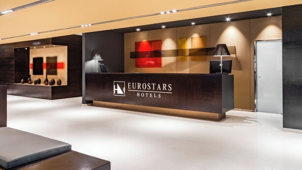 Un mostrador de recepción de diseño moderno, con el logotipo de Eurostars Hotels.