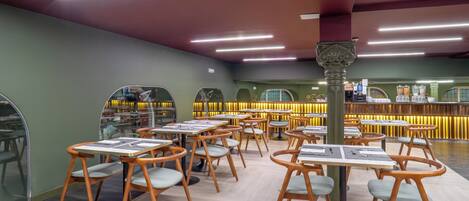 A restaurant with wooden tables and chairs, a bar area, and a modern interior design.