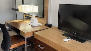Escritorio, cortinas blackout y tabla de planchar con plancha