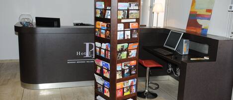 A reception desk with a dark wood finish, a glass display case, and a red bar stool.