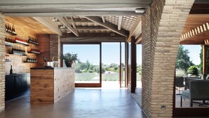 A spacious kitchen with a wooden island, a brick wall, and a large sliding glass door leading to an outdoor patio.
