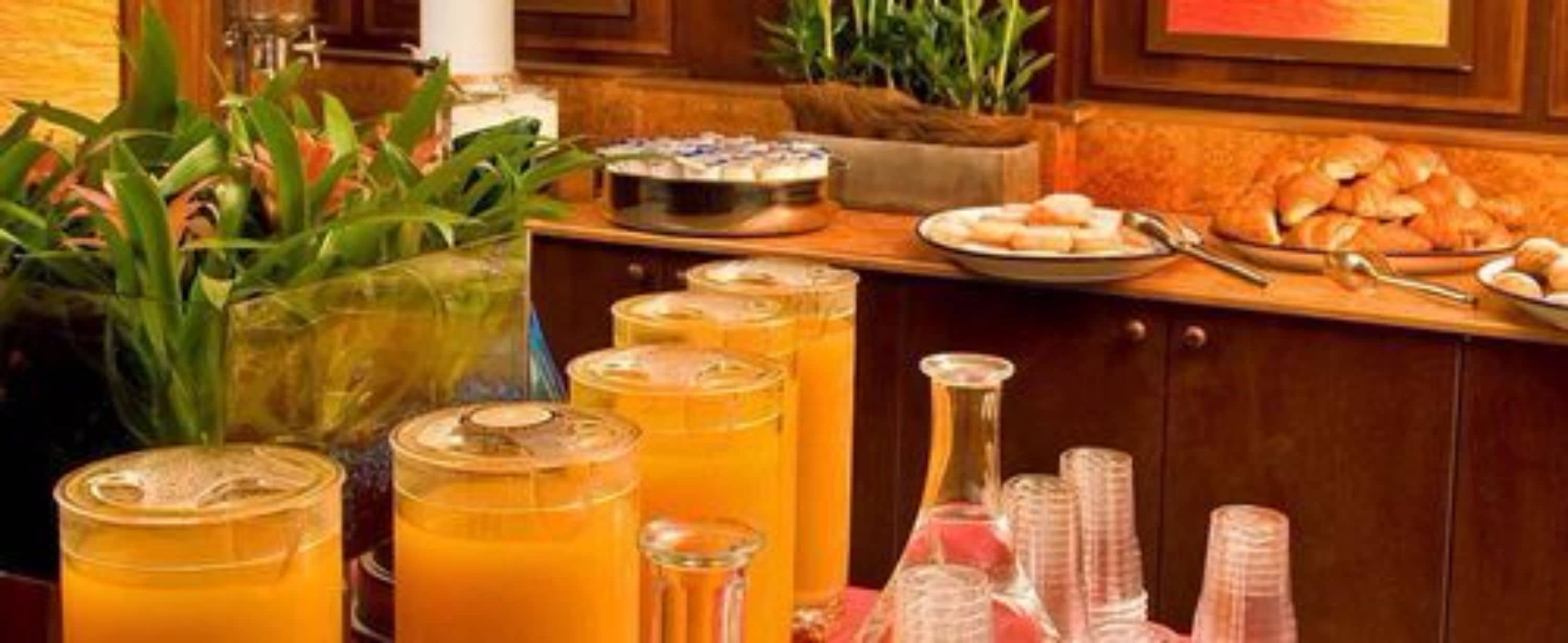 A buffet setup with various food items and drinks.