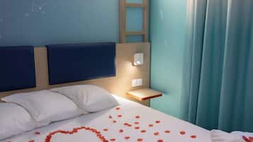 Une chambre d’hôtel avec un lit, un miroir rond, une échelle en bois et une table de chevet.