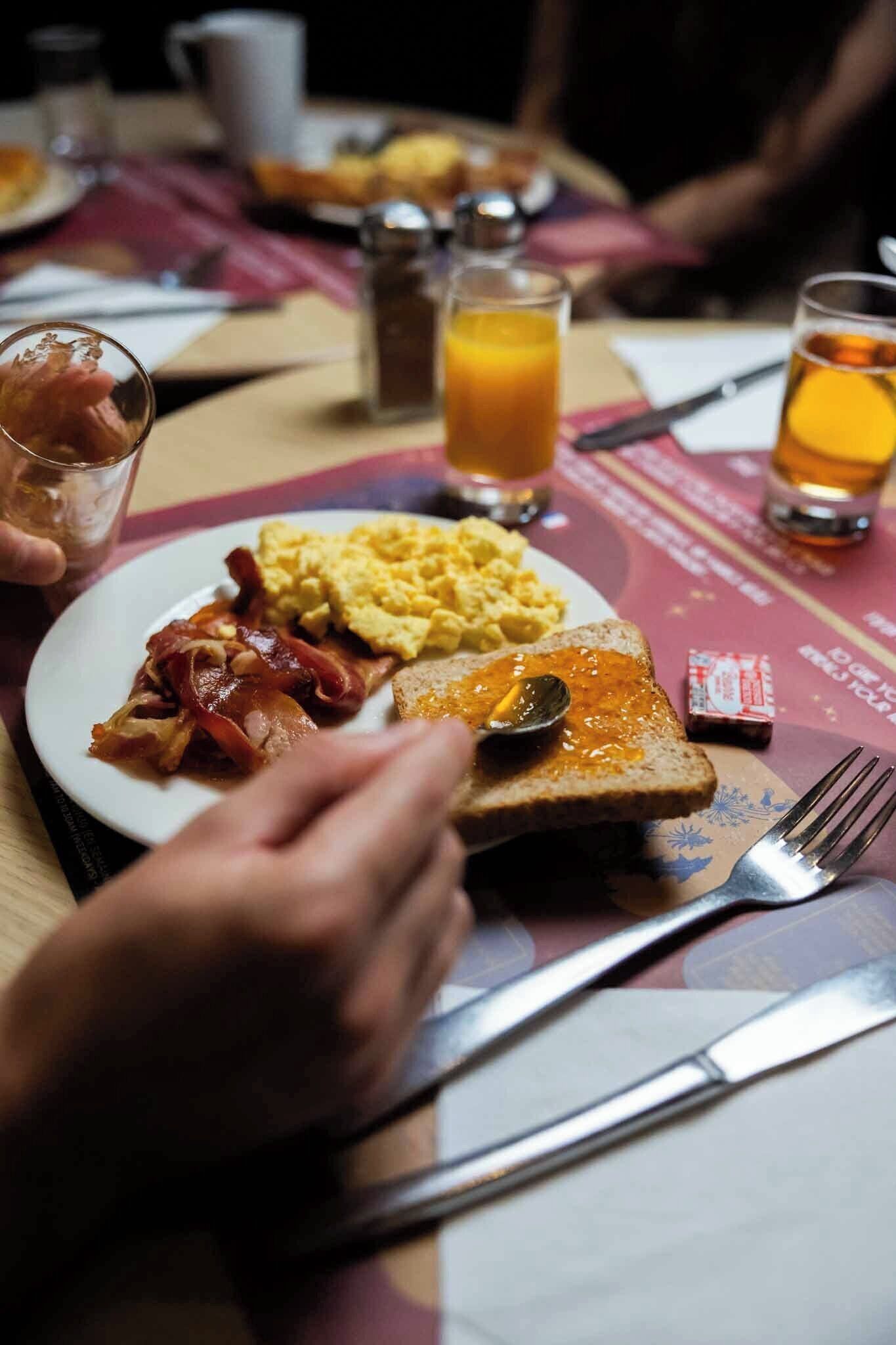 Un plat d'esmorzar amb ous, bacon, torrades i melmelada.