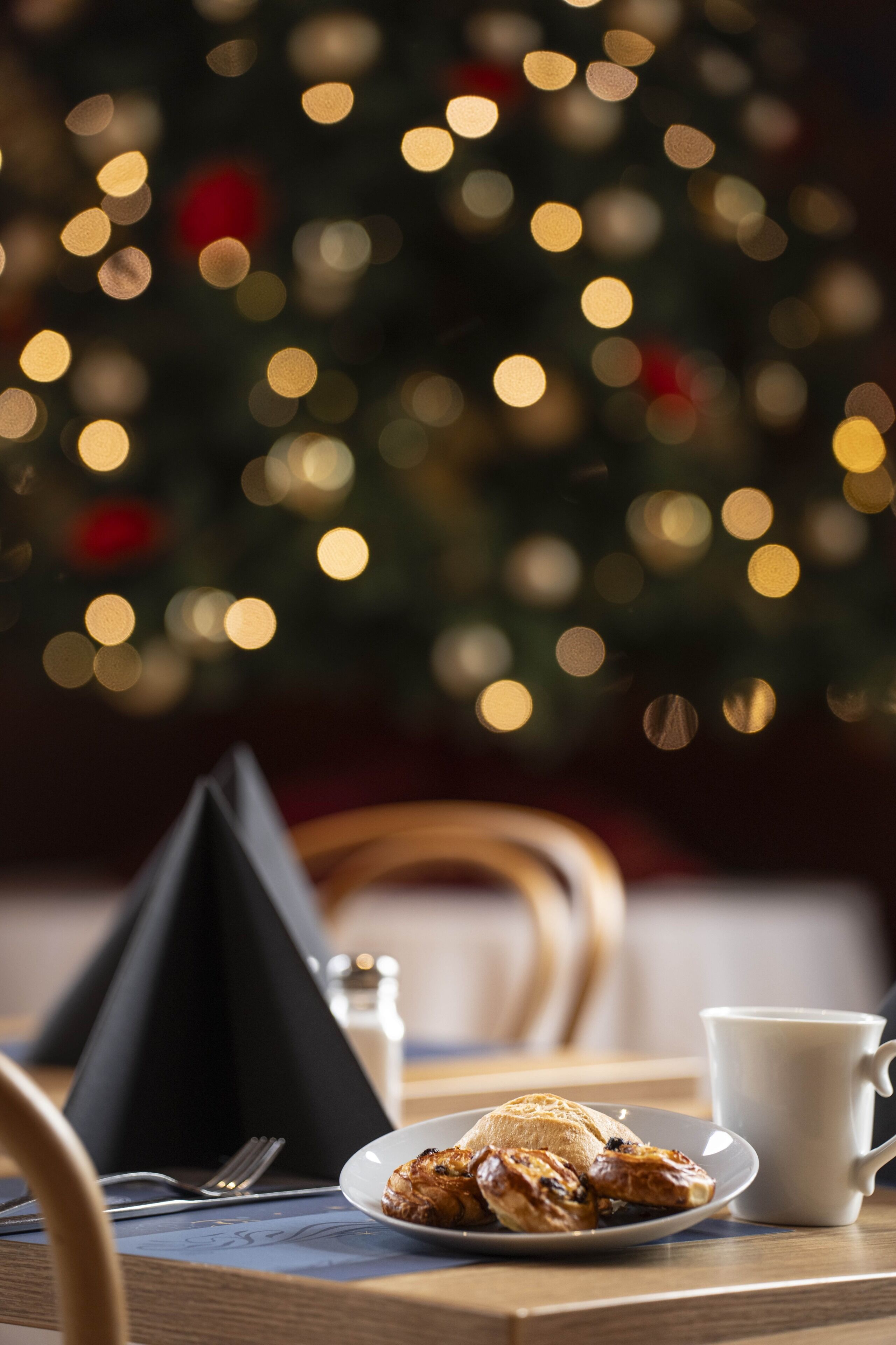 A dining table with a plate of food, a cup, and a napkin.