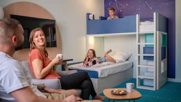 Una habitación con literas, un televisor de pantalla plana y un diseño de pared con estrellas.