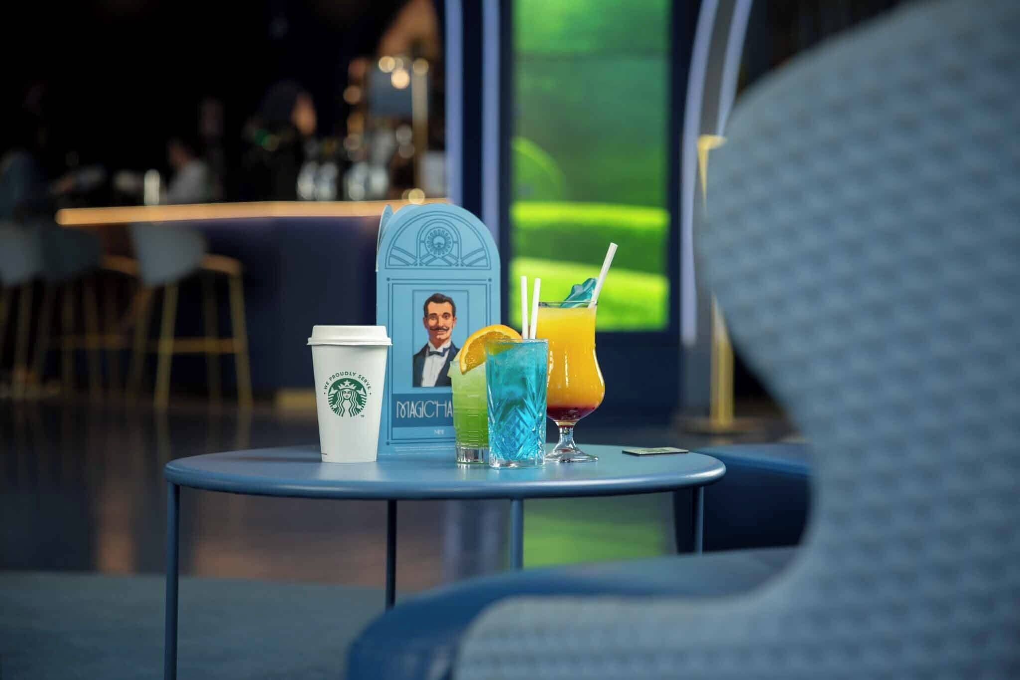 A table with a Starbucks cup, a drink with a straw, and a menu or sign with a photo.