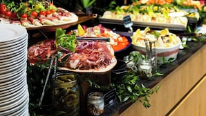 Un bufé con diversos alimentos y una lámpara colgante azul decorativa.
