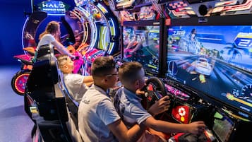 A gaming arcade with multiple racing game machines.