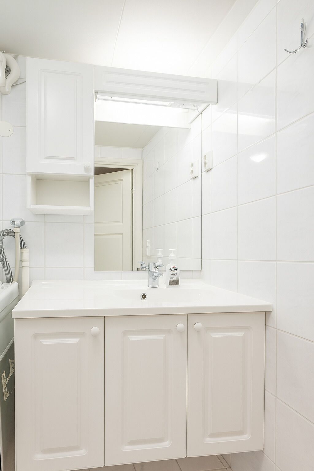A modern bathroom with a white vanity, a large mirror, and a sink.
