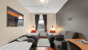 Una habitación de hotel moderna con dos camas individuales, un escritorio y una silla.