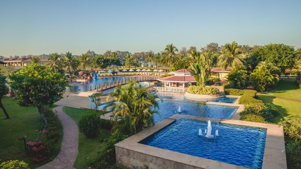 A resort with multiple swimming pools, palm trees, and a well-maintained garden.
