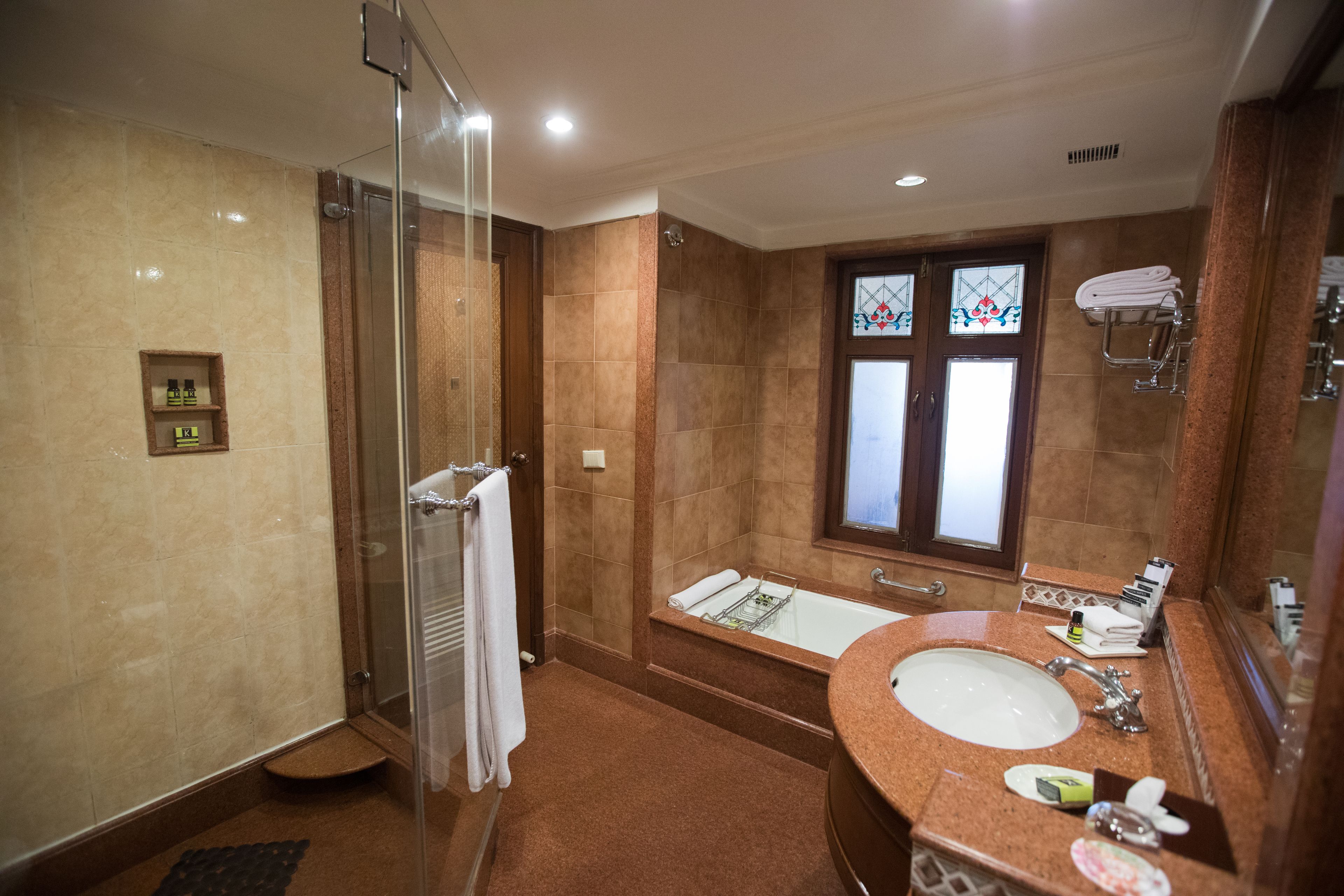 A modern bathroom with a glass-enclosed shower, a freestanding bathtub, and a vanity with a sink and mirror.