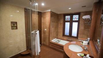A modern bathroom with a glass-enclosed shower, a freestanding bathtub, and a vanity with a sink and mirror.