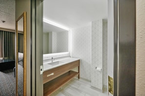 A modern bathroom with a wooden vanity, a large mirror, and a geometric patterned wall. - Wingate by Wyndham - Sylvania/Toledo (Sylvania)