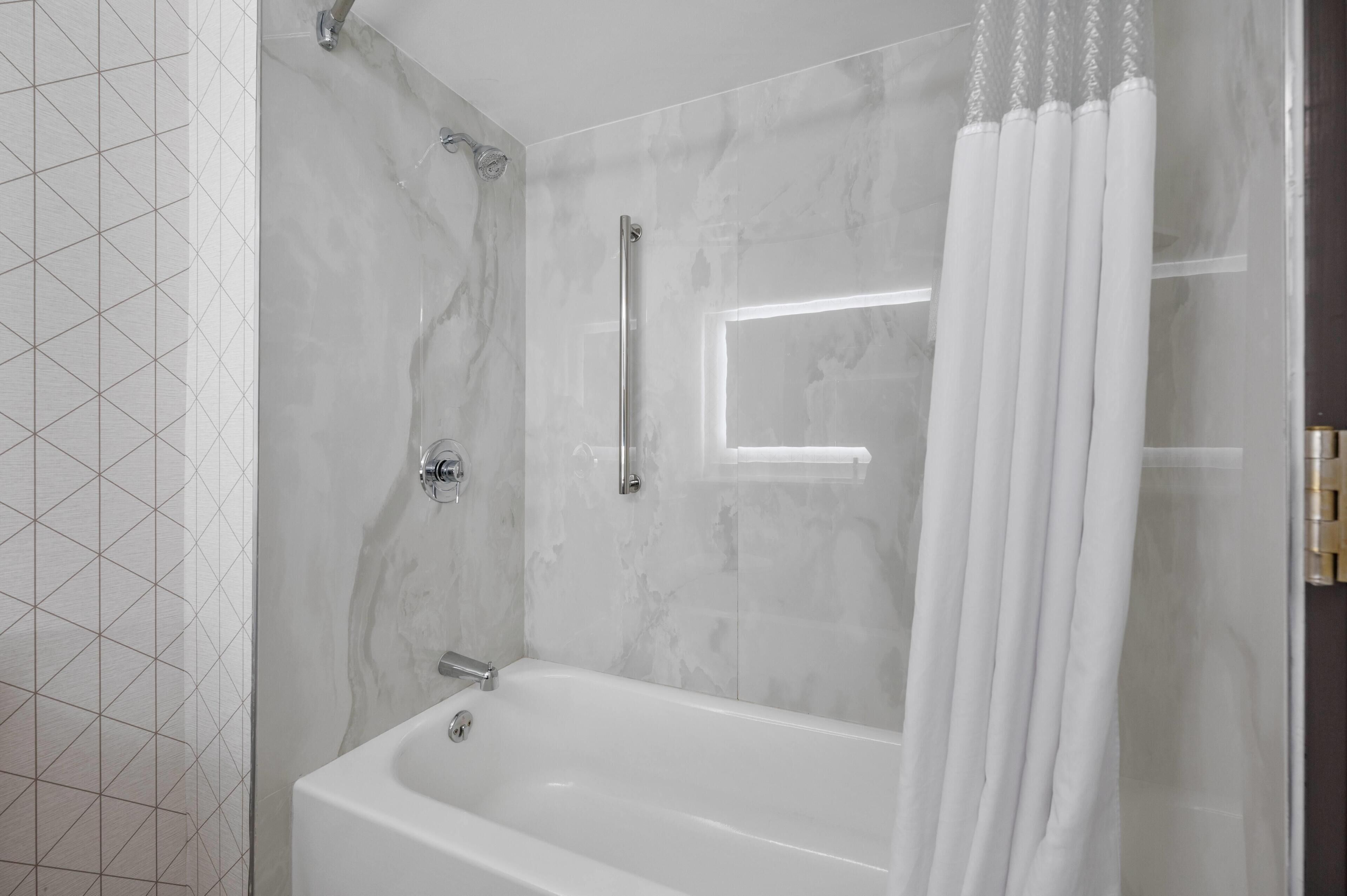 A bathroom with a bathtub, a shower, and a glass shower enclosure.