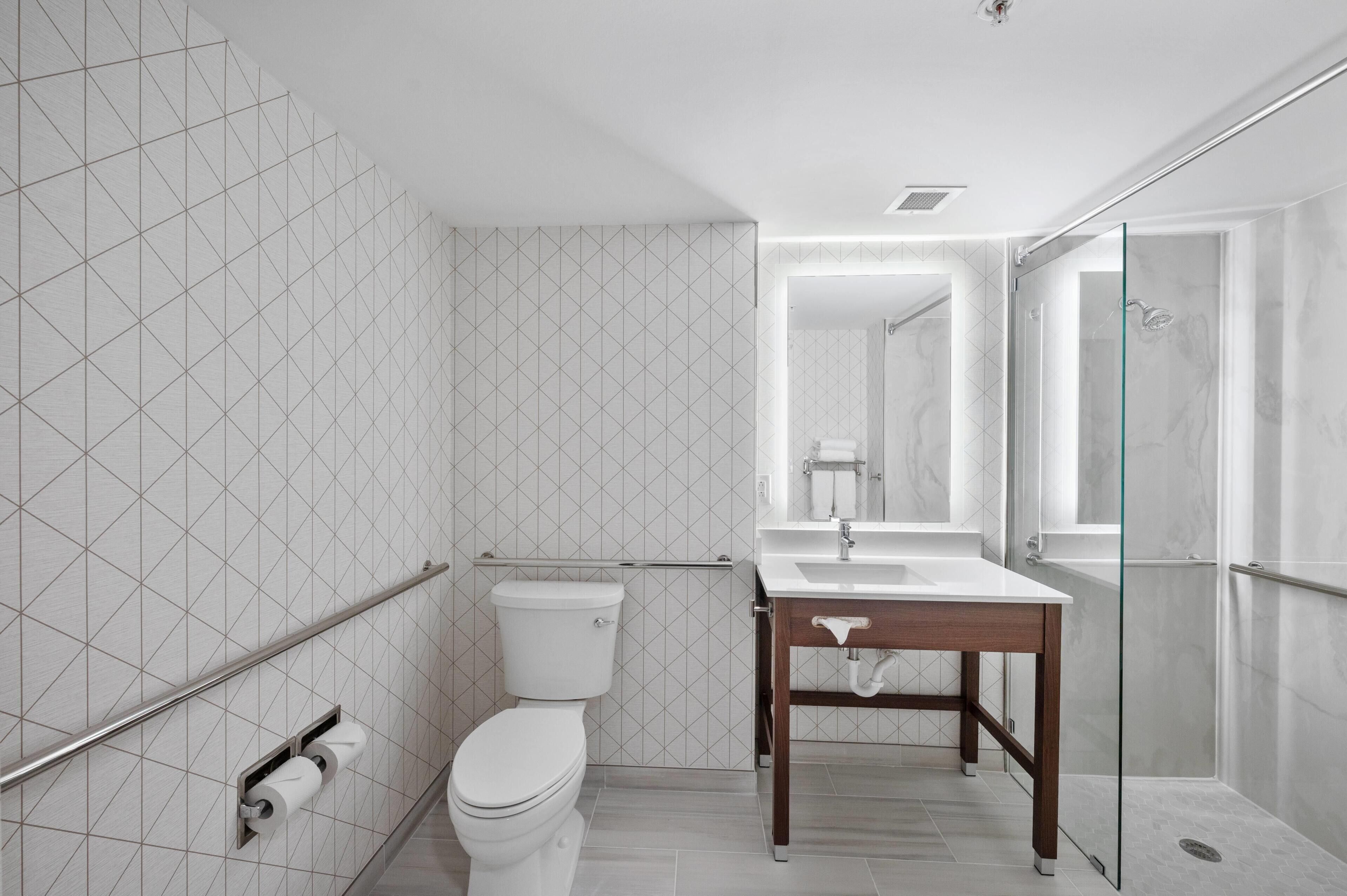 Een moderne badkamer met toilet, wastafel en douchecabine van glas.